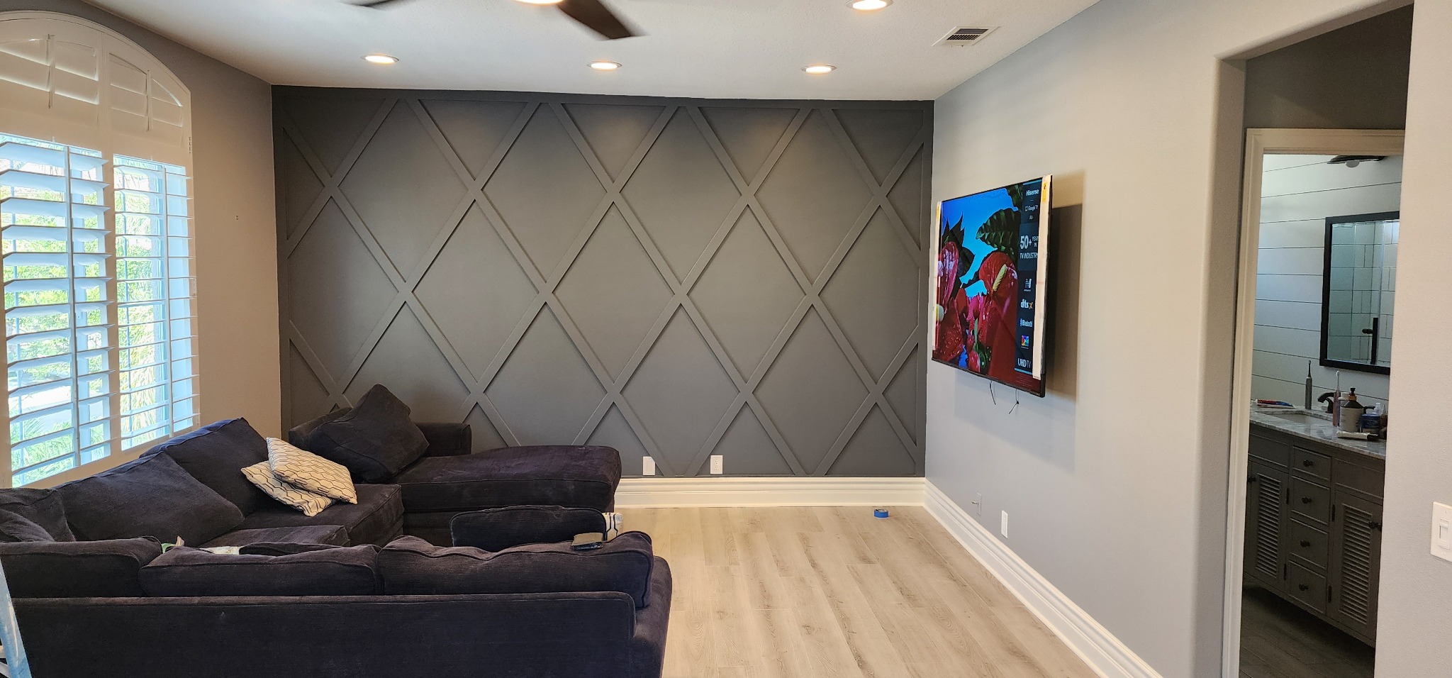 Living space with geometric accent wall and media area