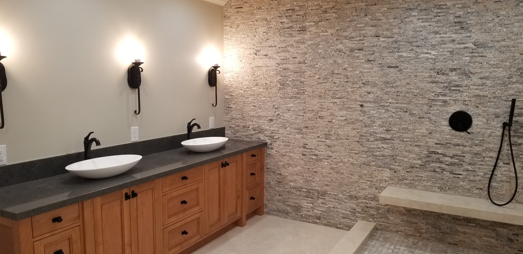 Bathroom vanity with vessel sinks and wall sconces