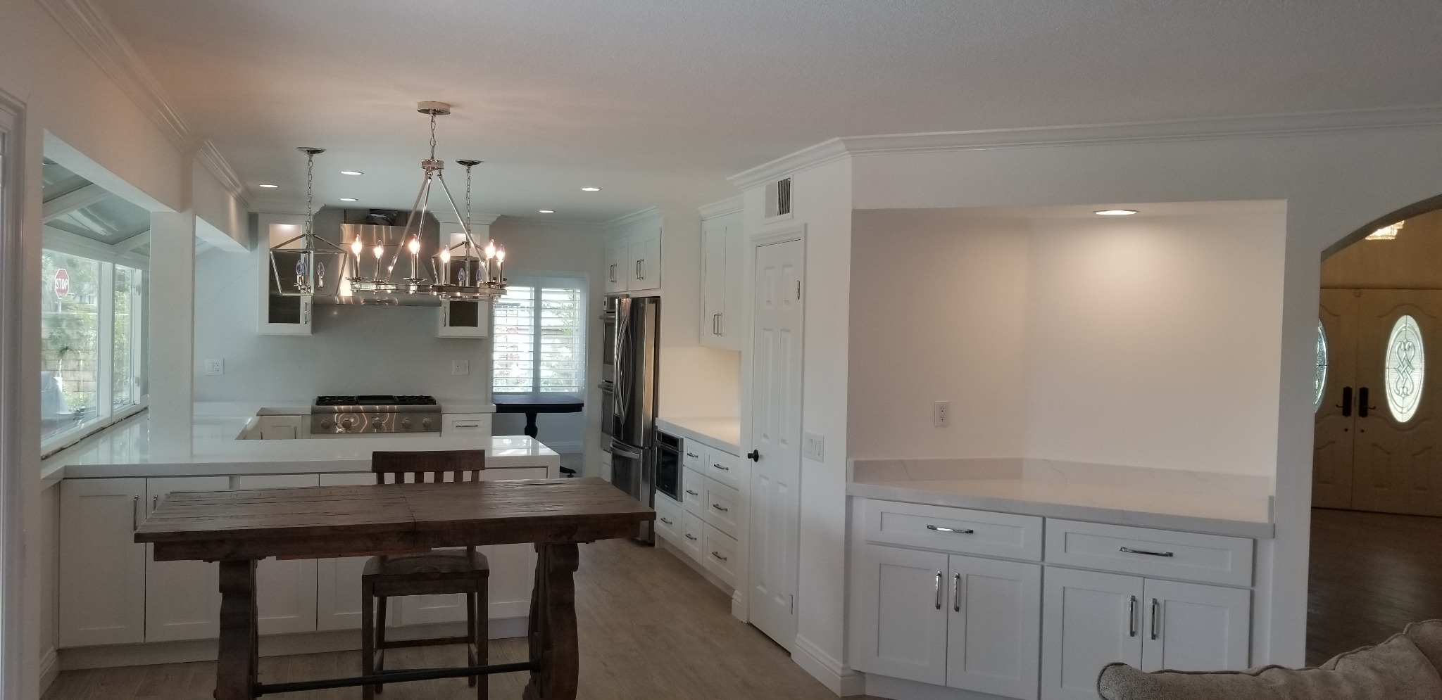 Bright open kitchen with white cabinetry and wood accents